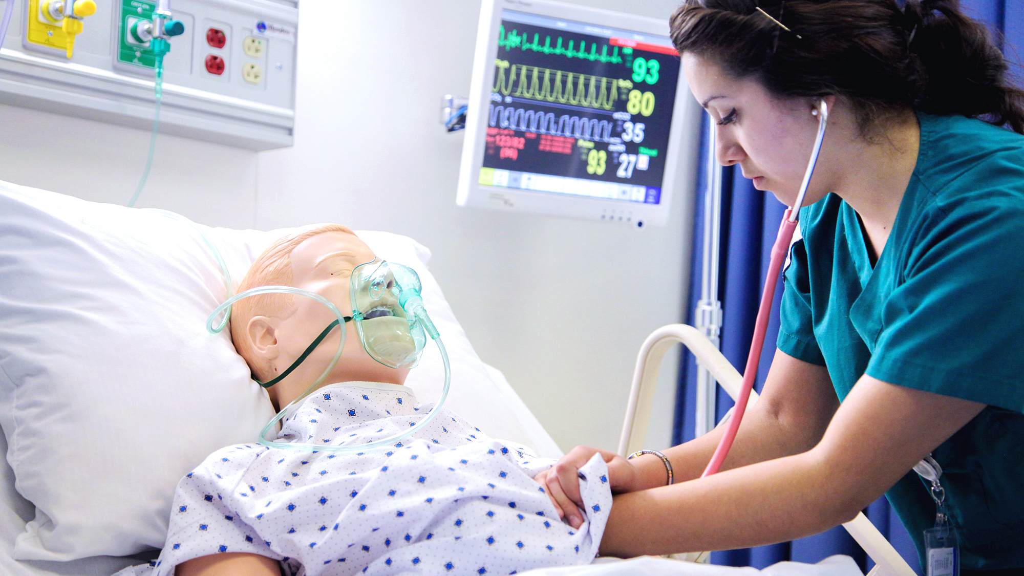 Studentessa che prende i parametri vitali ad un manichino durante una simulazione medica